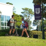 Two students walking outside of the Barter Student Center at Spring Hill College.