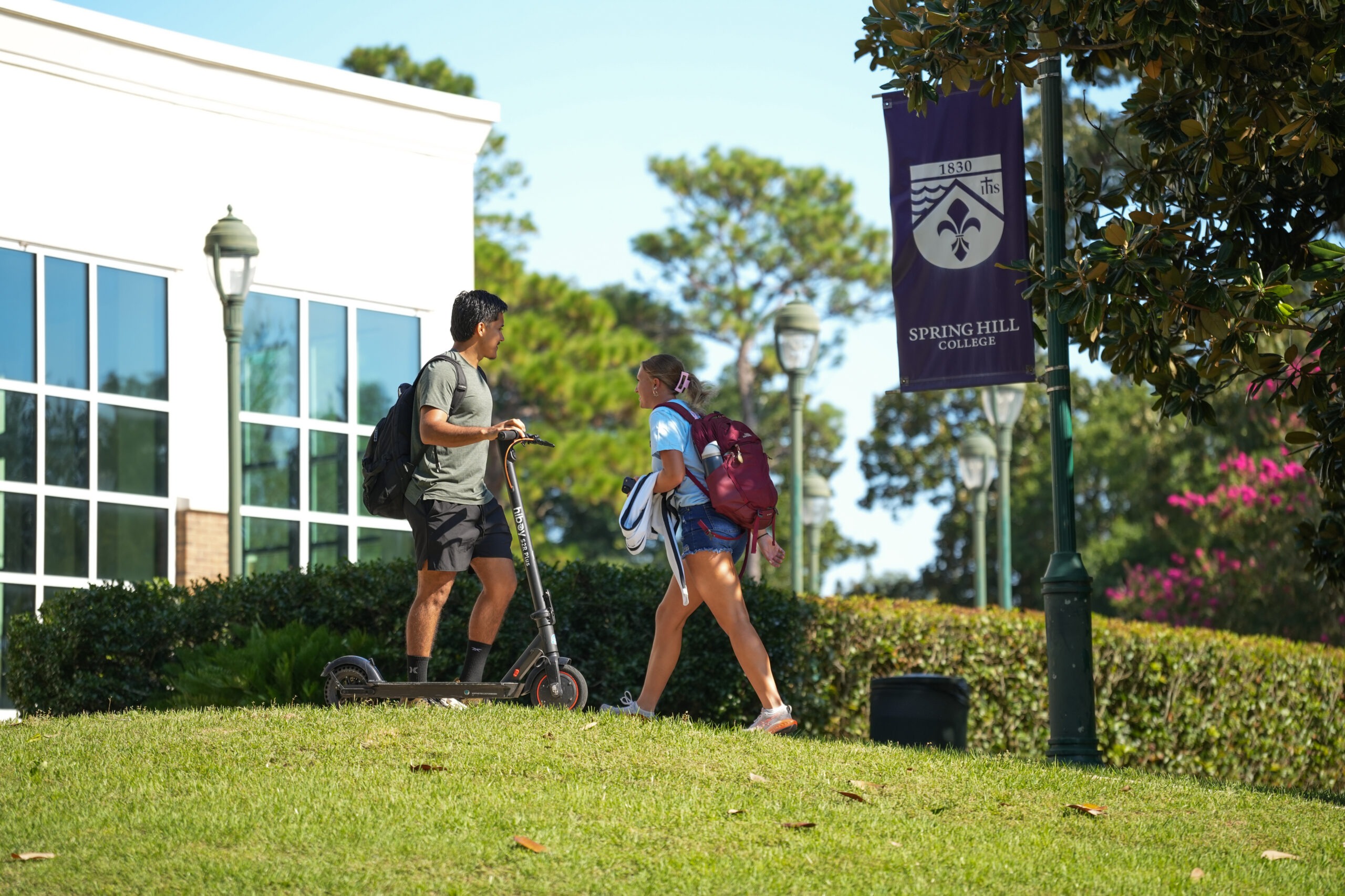Two students walking outside of the Barter Student Center at Spring Hill College.