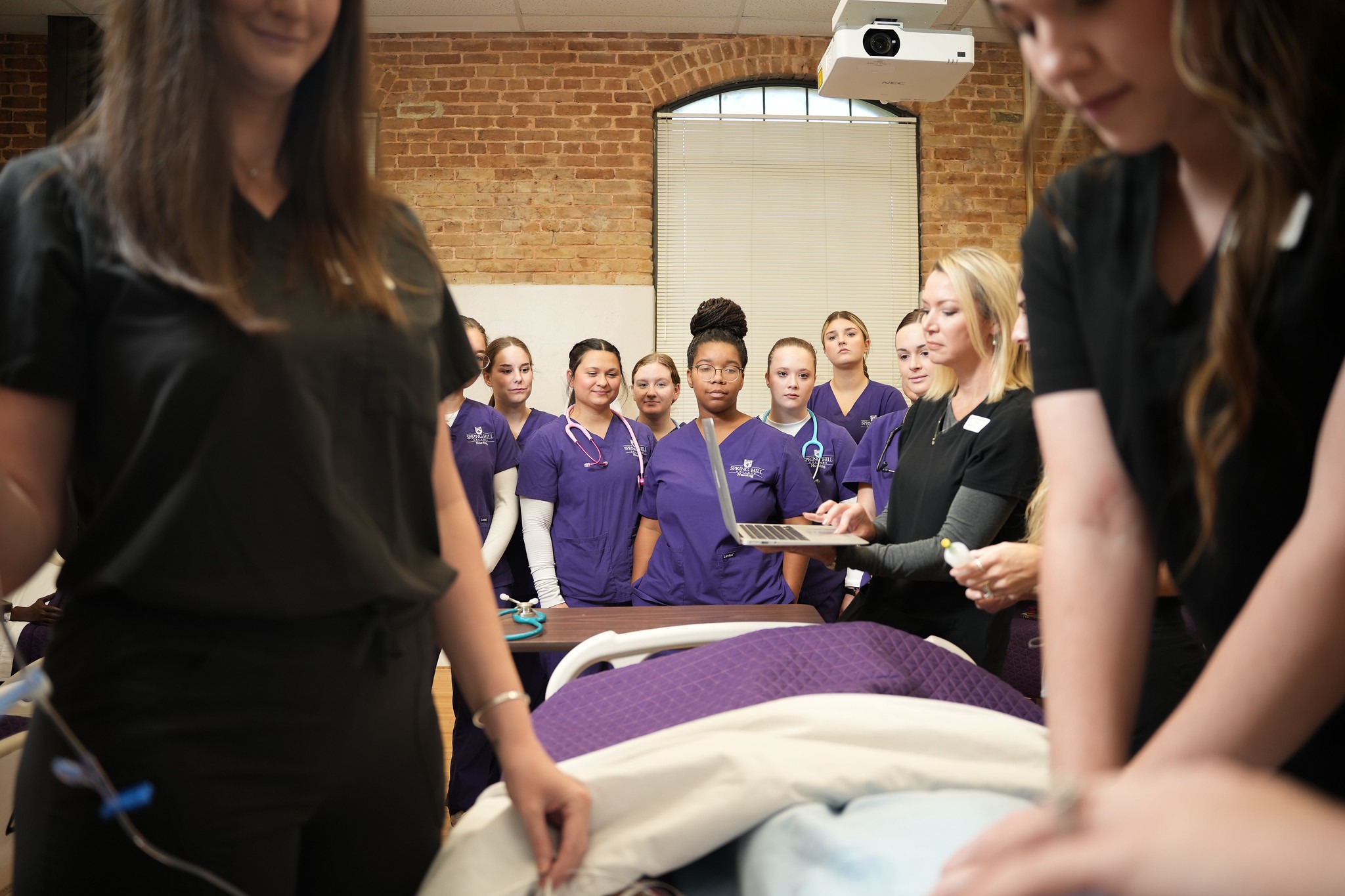 Group of nursing students watching demonstration.